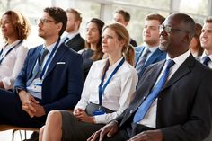 a group of people sitting next to each other in front of a man and woman