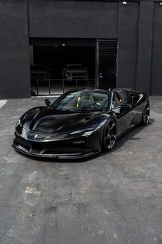 a black sports car parked in front of a garage