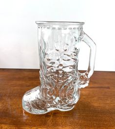 a glass mug sitting on top of a wooden table