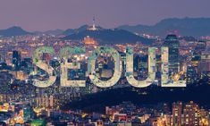 the word seoul in front of a cityscape with mountains and buildings at night