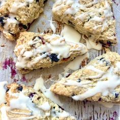 blueberry scones with white icing on a baking sheet