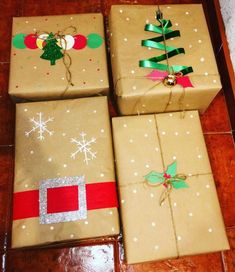 three wrapped presents sitting on top of a wooden table next to each other with christmas decorations