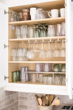 an open cabinet filled with lots of glassware