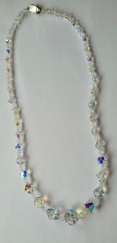 Vintage Aurora Borealis rainbow colors faceted graduated glass crystal necklace with a locking clasp decorated with clear rhinestones. Necklace is 22 inches long. There are 79 crystals largest being 16mm. Clasp is 1/2 inches. Excellent condition. Adjustable Faceted Crystal Necklace, White Faceted Crystal Necklaces, White Faceted Crystal Necklace, Clear Crystal Necklaces With Faceted Beads, Iridescent Crystal Jewelry With Faceted Beads, Faceted Round Crystal Bead Necklaces, Rhinestones Necklace, Feb 4, Glass Crystal