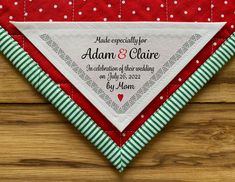 a red and green wedding handkerchief with white polka dots on it, sitting on top of a wooden surface