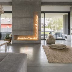 a living room with a fireplace and couches in front of the fire place on the wall