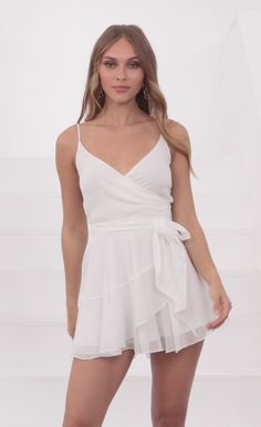 This ruffled wrap dress is about to be your favorite go-to dress for work, vacations and fun evenings out! With soft shimmery fabric, you'll never want to take it off. The wrap around makes for the most flattering fit and easy to slip on whenever you need! Pair with some white sneakers and hoop earrings to make for a comfy and cute ensemble.   Designed in Los Angeles - A-line Silhouette- Ruffled Trimming- Ties on Side- Dress is Sheer Length of Dress Measures 31in/78.74cm.All Measurements Are For Chic Party Wrap Dress With Ruffles, Elegant Mini Wrap Dress With Ruffles, Flirty Mini Wrap Dress With Tie Waist, Flirty Mini Length Wrap Dress With Tie Waist, Chic Flowy Wrap Dress For Party, Elegant Wrap Dress With Ruffles For Night Out, Ruffled Wrap Dress For Night Out, Flirty Ruffled Wrap Dress, Party V-neck Wrap Dress With Ruffle Hem