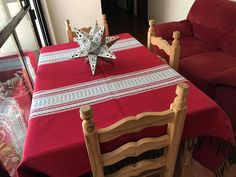 a red table cloth with a white star on it sits in front of a couch and loveseat