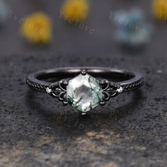 an engagement ring with a green stone in the center