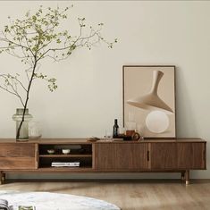 a living room with a plant and vases on the table next to a couch