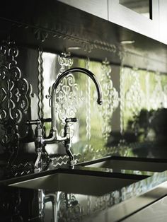 a kitchen sink sitting under a faucet next to a window