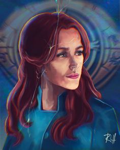 a woman with long red hair wearing a blue shirt and silver hoop earrings is looking to the side