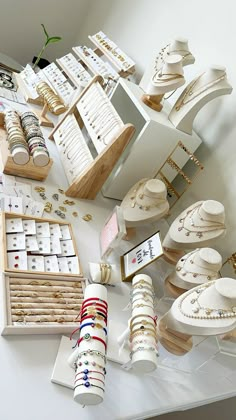 an assortment of jewelry and bracelets on display in a store window, with wooden boxes