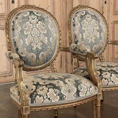 an ornately decorated arm chair in front of a wooden paneled wall and door