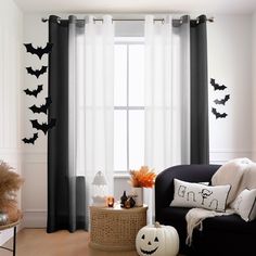 a living room decorated for halloween with black and white decor