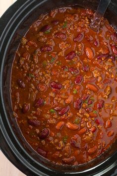 a crock pot filled with chili and beans