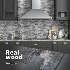 a kitchen with gray cabinets and tile backsplash, including a range hood over the stove