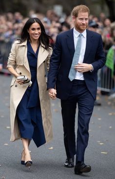 prince harry and his wife are walking down the street