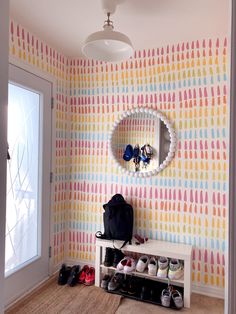 a room with colorful wallpaper and shoes on the floor