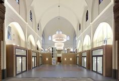 the inside of a large building with high ceilings and doors on both sides is empty