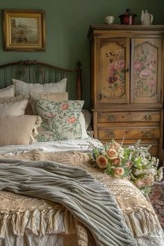 a bed with pillows and blankets on top of it next to a dresser in a bedroom