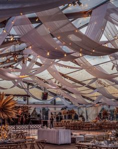 an indoor wedding venue with white draping and tables