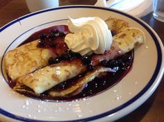 a plate topped with pancakes covered in fruit and whipped cream