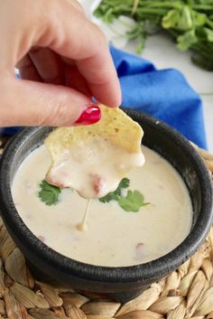 a person dipping some food into a bowl