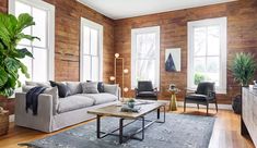 a living room filled with furniture and wooden walls