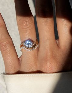 a woman's hand with a ring on it and a diamond in the middle