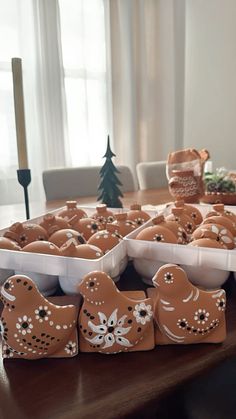 there are many ginger cookies in the trays on the table with christmas decorations around them