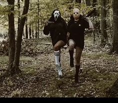 two people in costumes are running through the woods