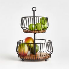 three tiered metal fruit stand with apples and pears in it on a white background