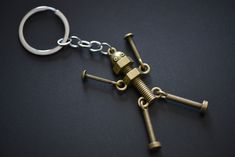 a metal keychain with two keys attached to it on a black surface,