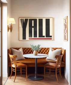 a living room with a couch, table and chairs next to a painting on the wall