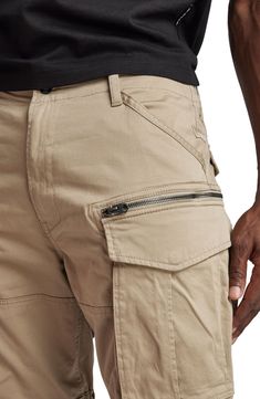 These stretch-cotton shorts feature large zip cargo pockets that add rugged and functional style you'll love for a day in the workshop or wilderness. 10" inseam; 22" leg opening; 12 3/4" front rise; 16 1/2" back rise (size 32) Zip fly with button closure Front slant pockets; side cargo pockets, back flap pockets 97% cotton, 3% elastane Machine wash, tumble dry Imported Raw Jeans, London Jeans, Woodland Camo, Tommy Hilfiger Jeans, Tapered Pants, Loose Shorts, Cargo Pant, Cargo Pants Men, G Star Raw