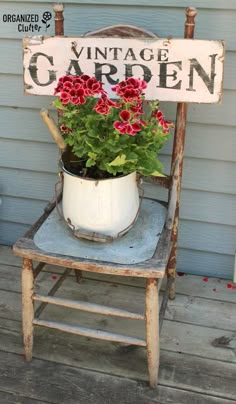 an old chair with a potted plant sitting on top of it, next to a sign that says vintage garden