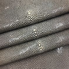 a close up view of a leather material with white dots on it and black background