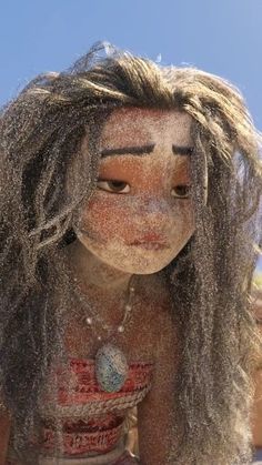 a woman is covered in sand with her hair blowing