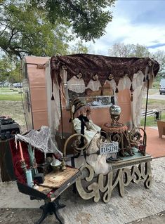 an old fashioned covered wagon is parked on the side of the road in front of a tree