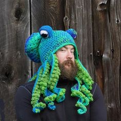 a man wearing a crocheted hat with a green and blue octopus on it