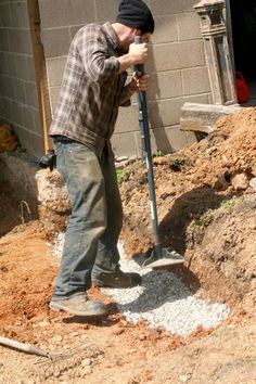 a man is digging in the dirt with a shovel