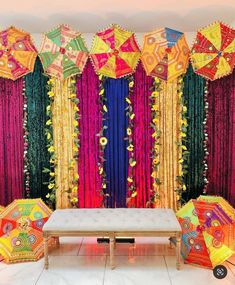 an elaborately decorated stage with colorful umbrellas and drapes on the wall behind it