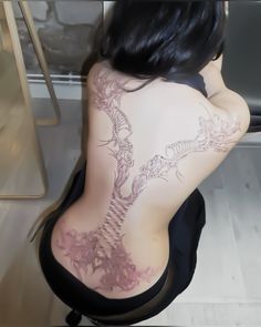 the back of a woman with tattoos on her body