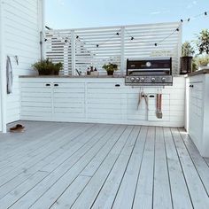 an outdoor kitchen with wood floors and white cabinets