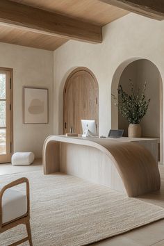 a large white room with an arched doorway and wood accents on the walls, along with a beige area rug