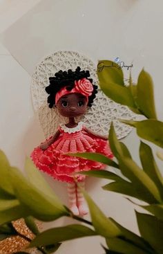 a doll is sitting on a table next to some plants