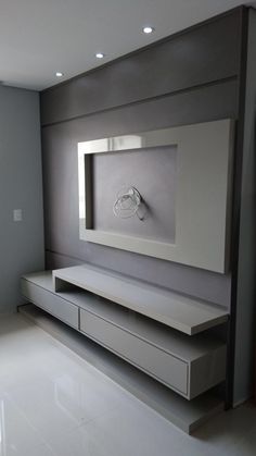 a modern living room with white tile flooring and gray wall mounted clock on the shelf