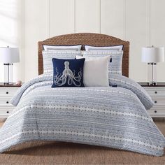 a bed with blue and white comforters in a room