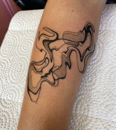 a black and white tattoo on the leg of a person's arm with an abstract design